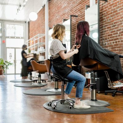 Hairstylist trimming hair of the customer in a beauty salon